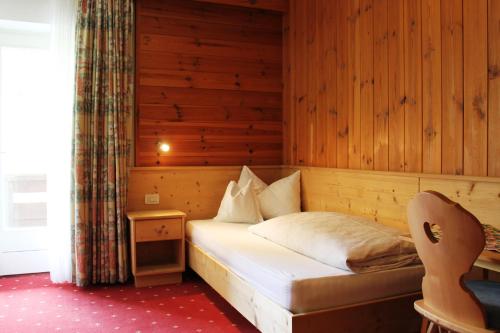 科瓦拉因巴迪亚阿力桑德酒店的木制客房内的一间卧室,配有一张床