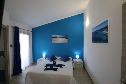 特乌拉达Guest house Ajo' a mulinu的蓝色卧室,配有蓝色墙壁的床