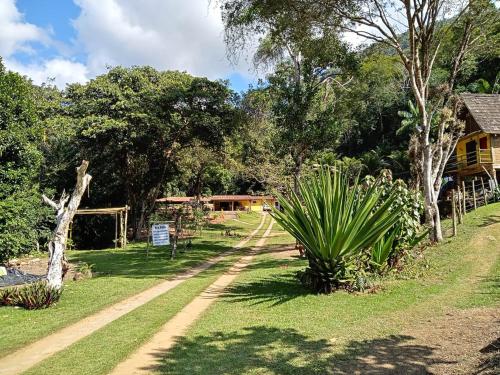 圣莱奥波尔迪娜Eco Parque Cachoeira Moxafongo的一条土路穿过树木和房屋的公园