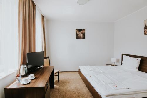 格但斯克雷比赫瓦瓦勒斯卡女士庄园的酒店客房设有一张床和一张带电视的书桌。