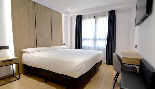 马德里UVE Marcenado的一间卧室配有一张床、一张书桌和一个窗户。