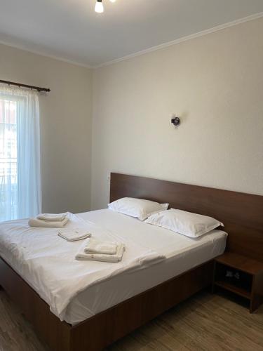 旧瓦马Vila Amir的一间卧室配有一张床,上面有两条毛巾