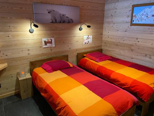 蒙乃第耶-勒潘Chalet Serre Chevalier的木墙客房的两张床