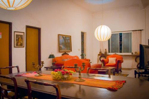 乌鲁瓜亚纳Hotel Solar dos Tchuccos的客厅配有桌子和橙色椅子