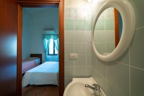 阿特里Dimora Terrazza sui Calanchi的一间带水槽和镜子的浴室以及一张床