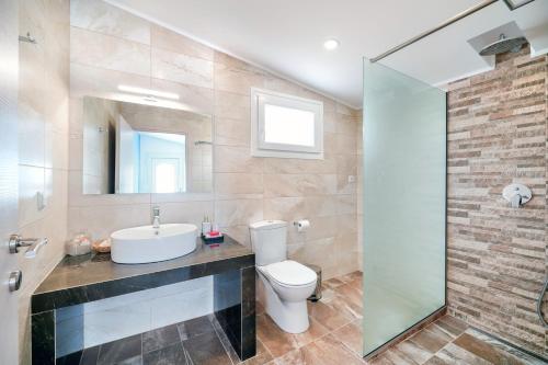 利迈纳里亚Villa Pines的一间带卫生间、水槽和镜子的浴室
