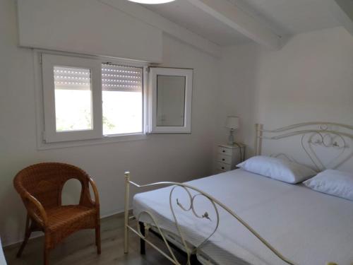 托雷拉皮罗Dimora Arnesano的一间卧室配有一张床和一把椅子,还有两个窗户