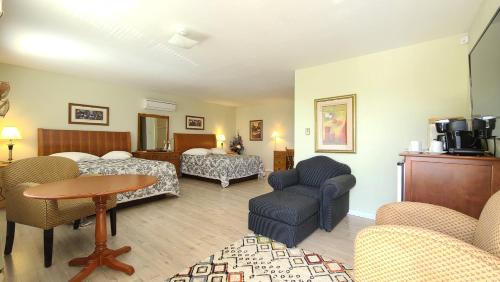 布克塔谢Bouctouche Bay Inn的酒店客房配有床、沙发和桌子。