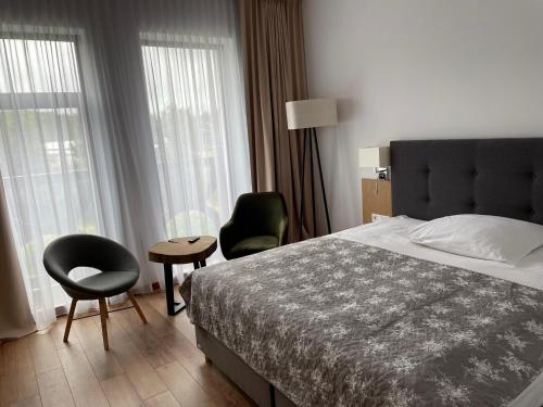 伊拉华斯达塔克酒店的一间卧室配有一张床、两把椅子和一张桌子