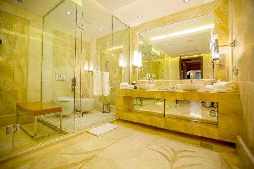 苏莱曼尼亚苏莱马尼千禧大酒店的大型浴室设有2个水槽和淋浴。