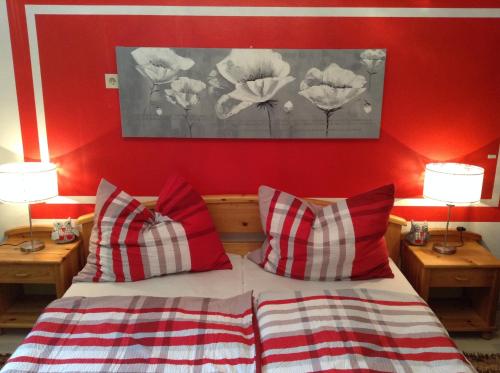 沃尔特湖畔佩莎赫卡拉克铃公寓的一间卧室设有红色的墙壁和一张带枕头的床