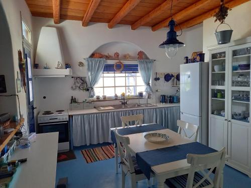 加夫里翁Exclusive Beach House的厨房配有桌椅和冰箱。