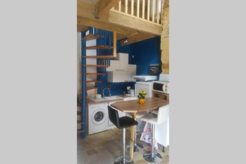 卡尔萨克阿亚克L'abreuvoir, Gite du 18 siecle, accés indépendant的一个带桌子和楼梯的小厨房