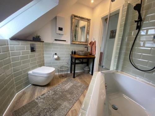 波鸿Blick ins Ruhrgebiet的浴室配有卫生间、盥洗盆和浴缸。