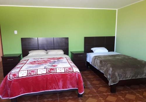 万卡约La Azotea的一间卧室设有两张床,拥有绿色的墙壁