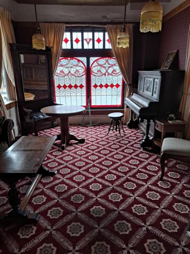 西沃德范吉尔德酒店的一间设有桌子、钢琴和窗户的客房
