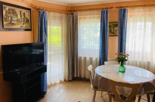 根尼斯迪亚斯Lili nyaralóház的客厅配有桌子、电视和桌椅