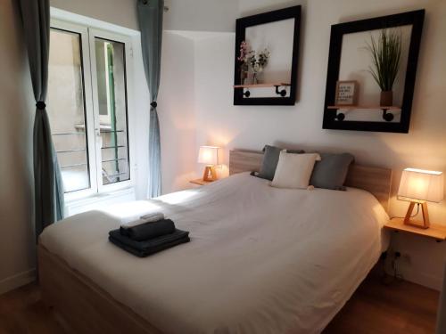 尼斯Beautiful Old Town flat, near the beach的卧室配有白色床、两盏灯和一扇窗户。