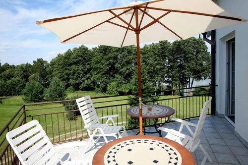 文戈热沃马瑞别墅酒店的庭院配有桌椅和遮阳伞。