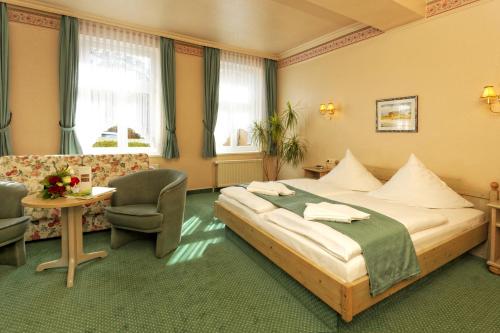 奥斯特西巴德钦诺维茨Hotel Sonneneck的酒店客房带一张床、一张桌子和椅子