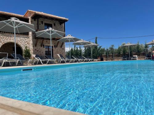米斯特拉斯Mystras Grand Palace Resort & Spa的一个带椅子和遮阳伞的大型游泳池