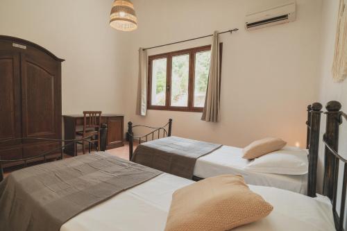 弗卢米尼马焦雷Anima Hotel Sardinia的一间卧室设有两张床和窗户。