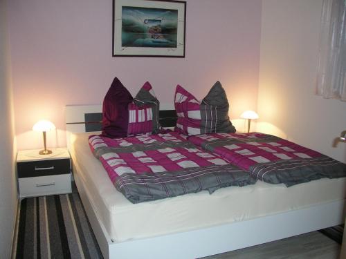 柏林新威尼斯之家公寓的一间卧室配有一张带紫色枕头的大床