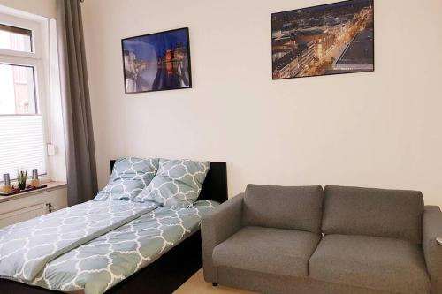 杜伊斯堡Apartment in Neudorf Nahe DU Zentrum und Uni/Zoo的一间卧室配有沙发、一张床和椅子