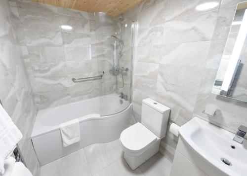 克罗斯黑文Whispering Pines的浴室配有卫生间、浴缸和水槽。