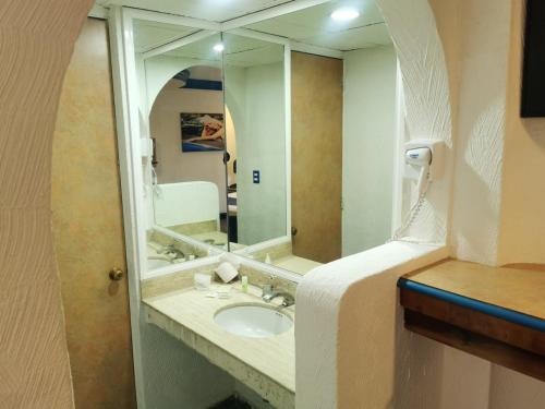墨西哥城Hotel Coacalco的一间带水槽和大镜子的浴室