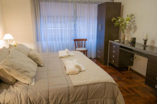 科尔多瓦Departamento del Boulevard的一间卧室配有一张大床和毛巾