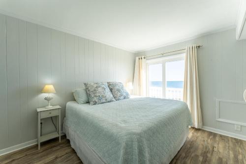 默特尔比奇Charming Ocean-view Condo at Ocean Pier 3的白色的卧室设有床和窗户