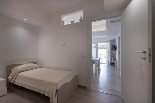 滨海波利尼亚诺B&B Il più bello dei mari的一间白色卧室,配有一张床和一个走廊