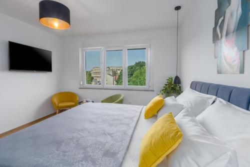 普拉Sylvia Center Apartment的卧室配有一张带黄色枕头的大型白色床。