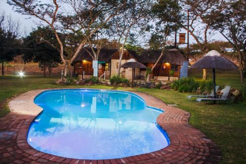 内尔斯普雷特Ndalo Lodge Mbombela的四周环绕着砖砌走道的游泳池