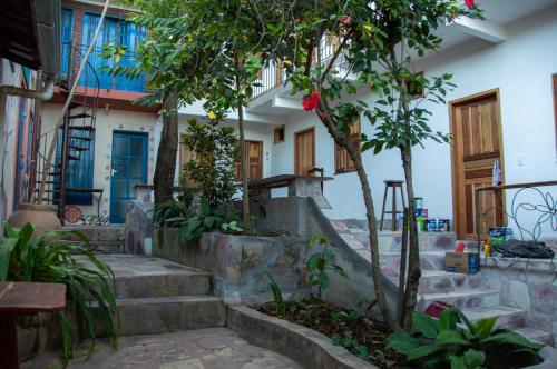伦索伊斯Chapada Backpackers Hostel Agência的前面有楼梯和树木的房子