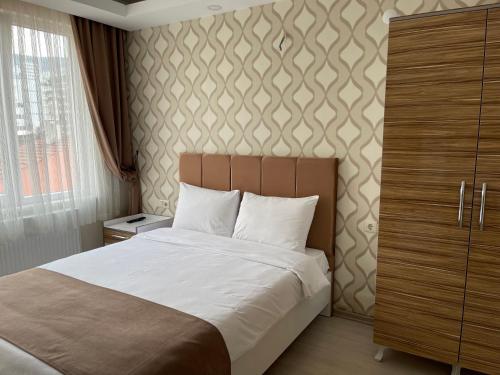 伯萨Bursa Malkoc Hotel的一间卧室设有一张床和一面墙