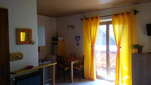 坎波罗索因瓦尔坎纳尔Huatscher的一间设有滑动玻璃门和黄色窗帘的房间