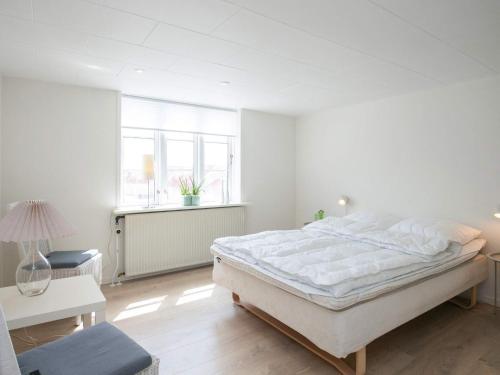 洛肯6 person holiday home in L kken的白色的卧室设有一张大床和一个窗户