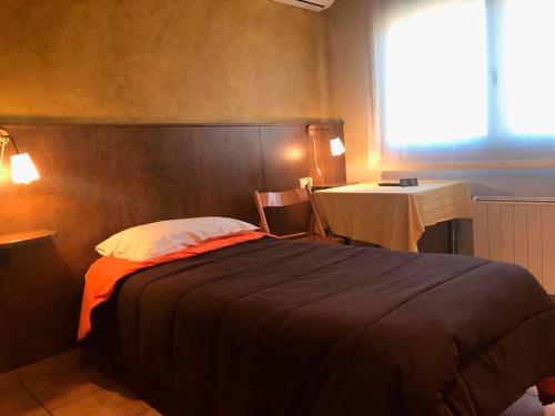 巴加HOTEL FAMILIAR BAGA的一间卧室配有一张床、一张桌子和一个窗户。
