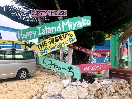 宫古岛Happy Island Miyako的建筑前有路标的柱子