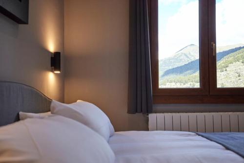 索尔德乌Soldeu Gall de Bosc Luxury Apartment apt Bon aire的一间卧室设有一张床,窗户享有美景