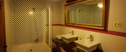 RomancosLa Noguera de Socasa的浴室设有2个水槽、浴缸和镜子