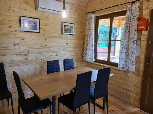 库尔泽尼克Siedlisko nad jeziorem Skarlińskim 5B, mazury, jezioro, domek, bania的一间带木桌和椅子的用餐室