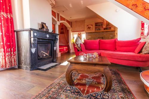 费伦Little India Vijlen appartement 2的客厅设有红色的沙发和壁炉
