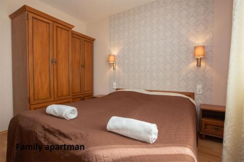 豪伊杜索博斯洛Liza Apartmanok的一间卧室配有一张床,上面有两条毛巾