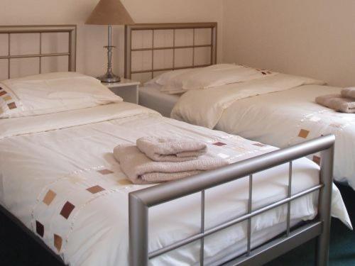 埃克斯茅斯Breken Guest House的卧室内的两张床和毛巾