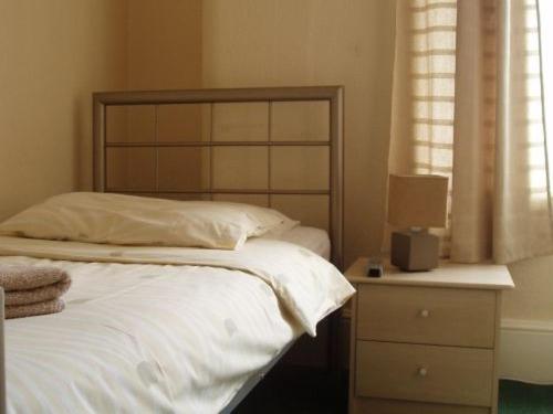 埃克斯茅斯Breken Guest House的一间卧室配有一张床、一个梳妆台和一扇窗户。