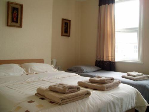 埃克斯茅斯Breken Guest House的一间卧室配有两张带毛巾的床