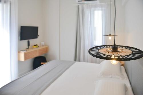 纳克索乔拉Princess Mare Hotel - Adults Only的一间白色卧室,配有床和电视